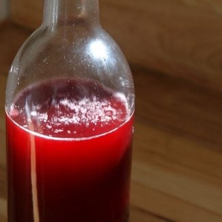 A bottle of finished, red raspberry vinegar