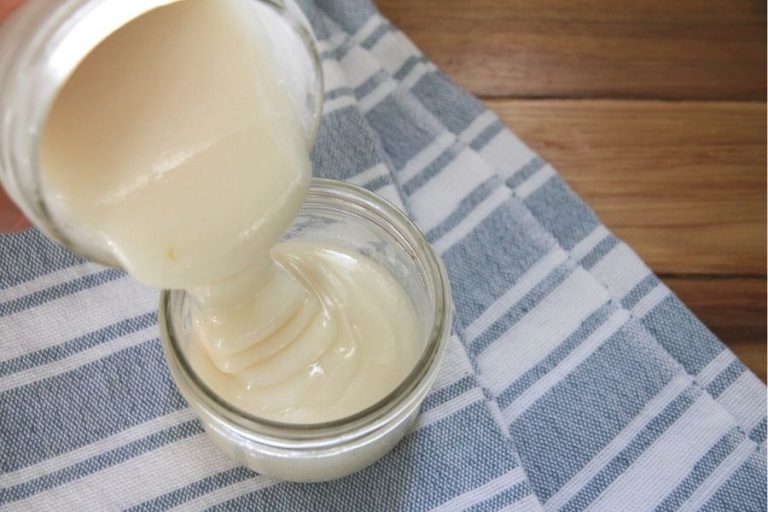 creamed honey being poured into a small jar
