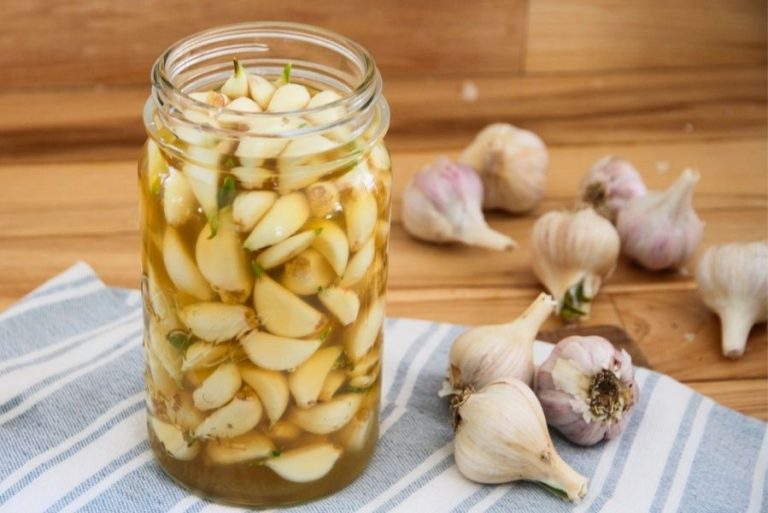a jar of peeled garlic covered in golden apple cider vinegar