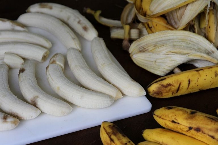 Freshly peeled bananas on a cutting board