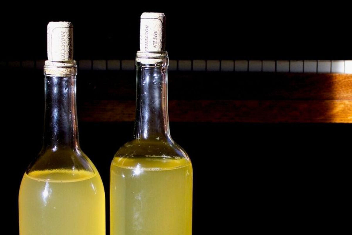 Corked glass bottles of golden grape vinegar, made from green table grapes.