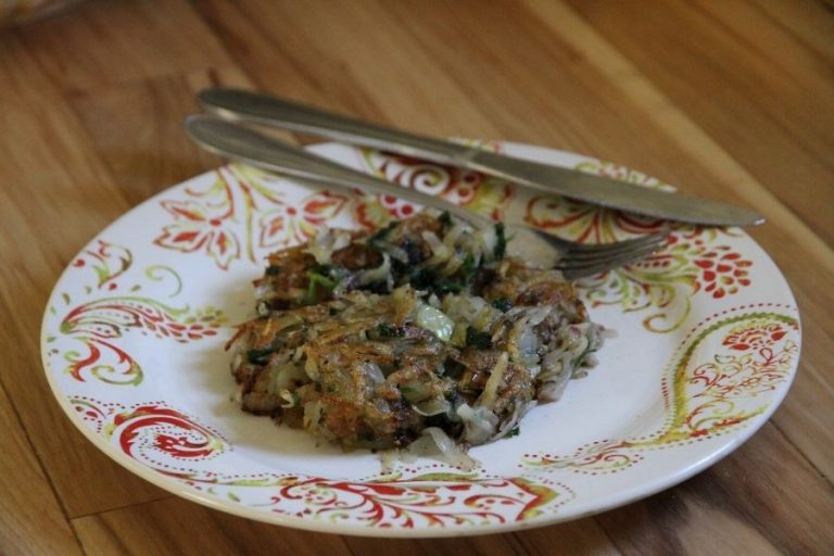 a plate, fork and knife with a crispy fried potato patty