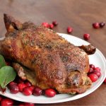 A steaming hot, roasted duck ready for carving
