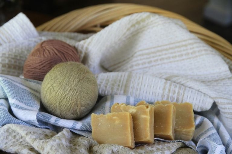 A basket of laundry with wool dryer ball and homemade soap bars