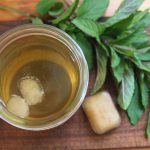 a mason jar of iced tea with cubes of mint tea concentrate floating on the surface