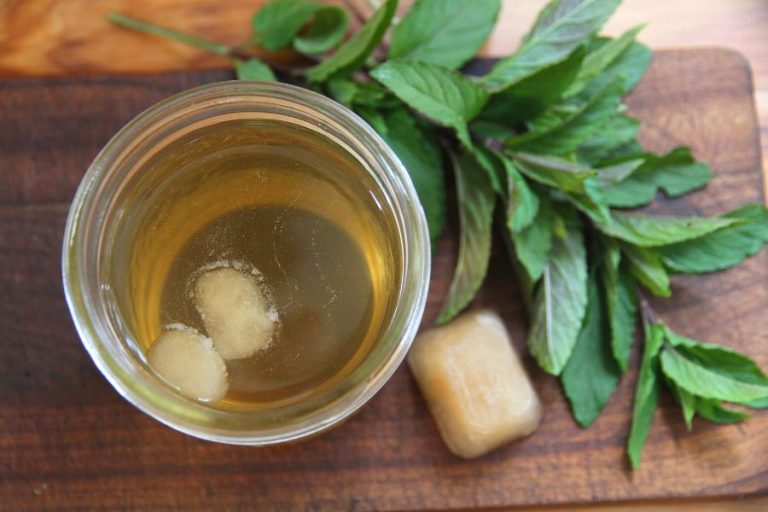 a mason jar of iced tea with cubes of mint tea concentrate floating on the surface