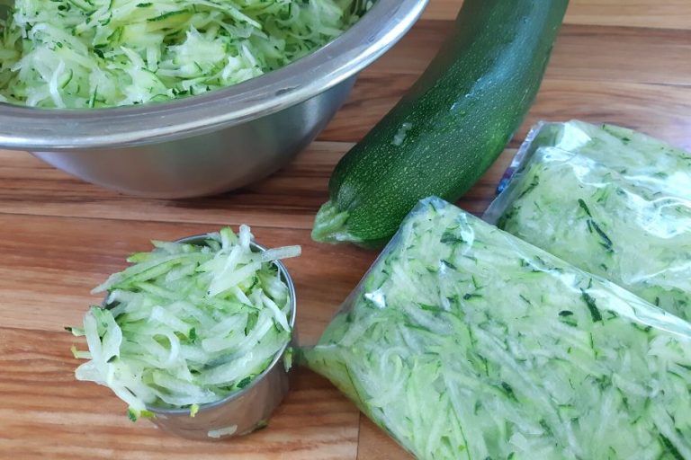 measuring out grated zucchini cup by cup and bagging it for the freezer
