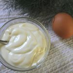 a spoon in a0 bowl of thick, white, homemade mayonnaise