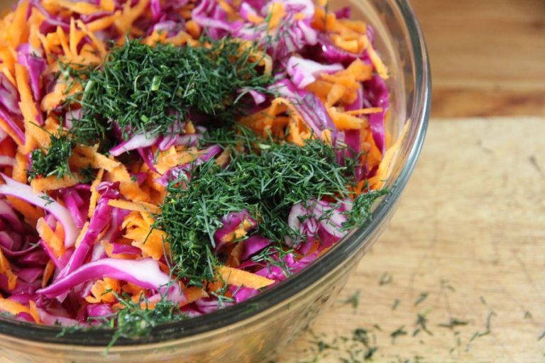 raw cabbage, carrot and dill in a bowl, ready to be mixed