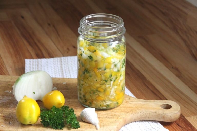 A jar of fermenting yellow tomato salsa with hot peppers