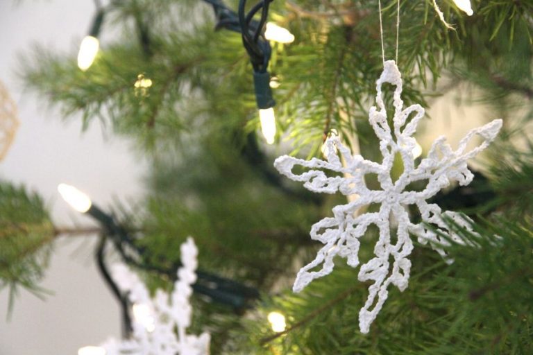 A crocheted and starched snowflake hanging on the Christmas tree
