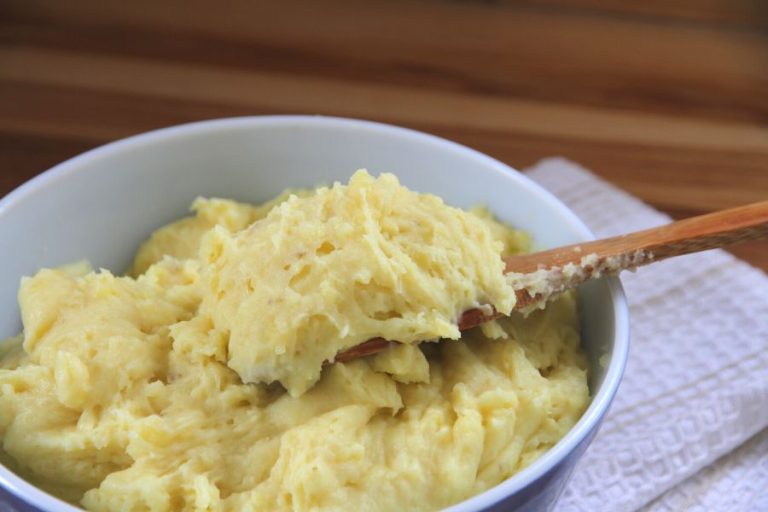 a blue bowl filled with yellow fluffy mashed potatoes