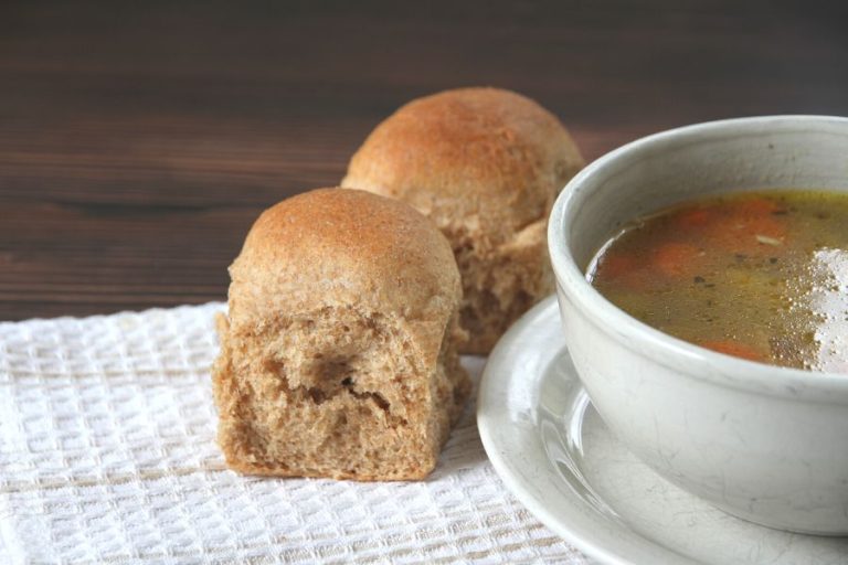 whole wheat dinner buns next to a bowl of chicken soup