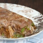 a brown and white platter hold a loaf of homemade head cheese