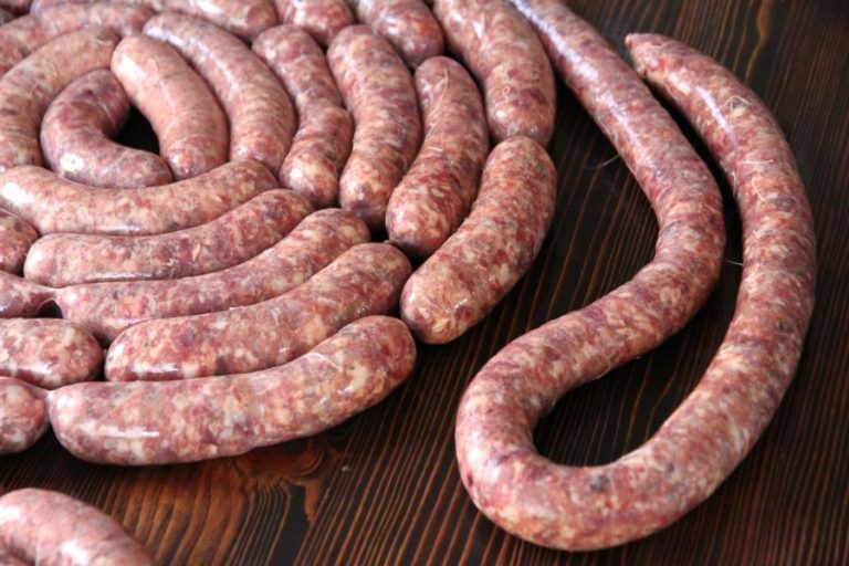 A coil of homemade garlic venison sausage on a tabletop