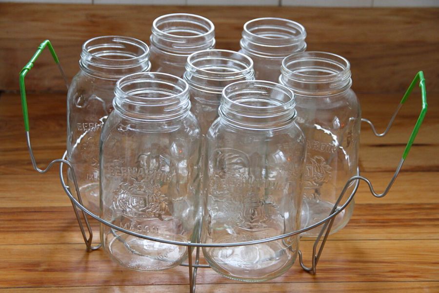 Glass jars sitting a wire rack on the kitchen counter.