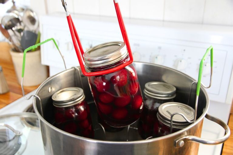 A water bath canner filled with jars of home canned sweet cherries.