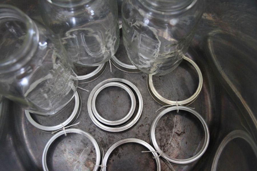 Metal screw bands that have been tied together for a makeshift rack in a large stock pot.