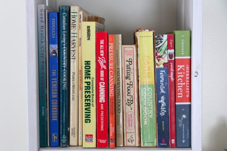 Rows of canning books and cookbooks on my kitchen shelf