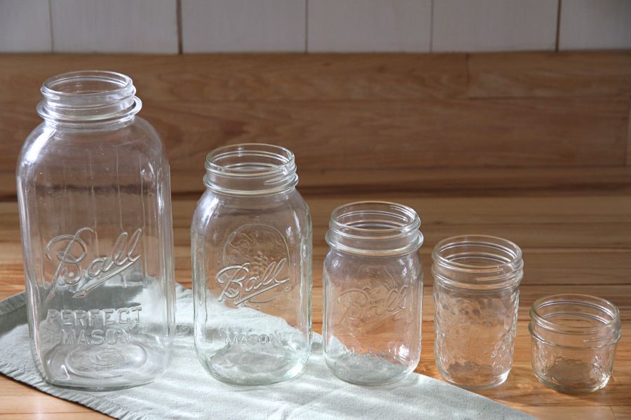 A row of standard size canning jars on the kitchen counter.