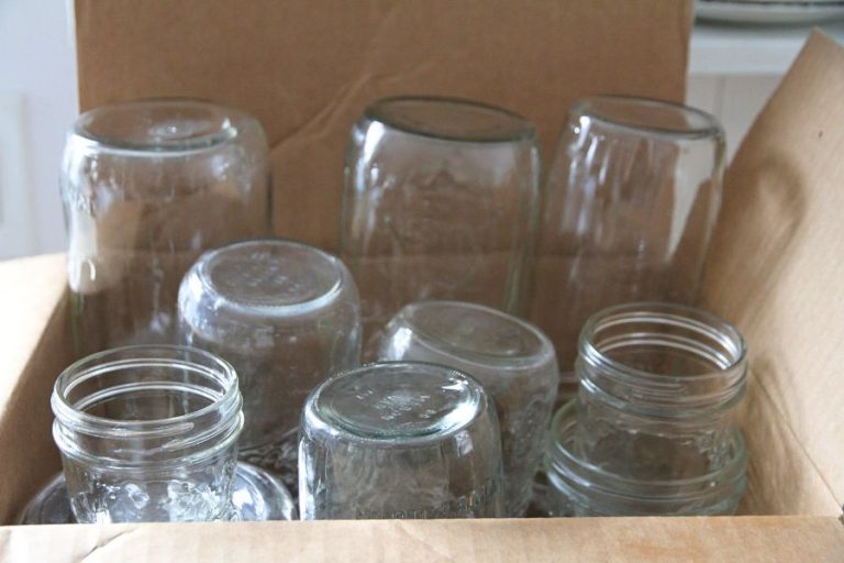 A cardboard box of glass canning jars, ready to be moved.