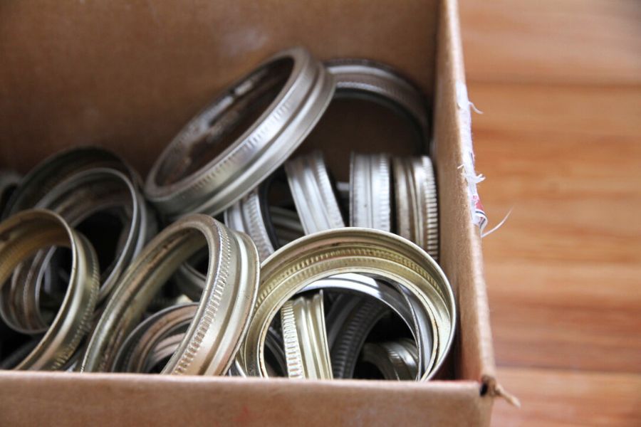 An assortment of metal screw bands in a cardboard box.
