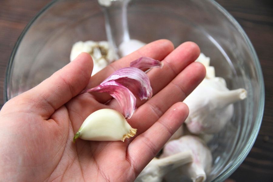 A peeled clove of raw garlic, ready to be minced.