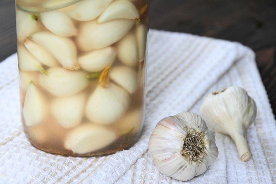 A jar of fully fermented garlic with cloudy brine.