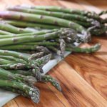 Bundles of fresh asparagus laid out on the kitchen counter
