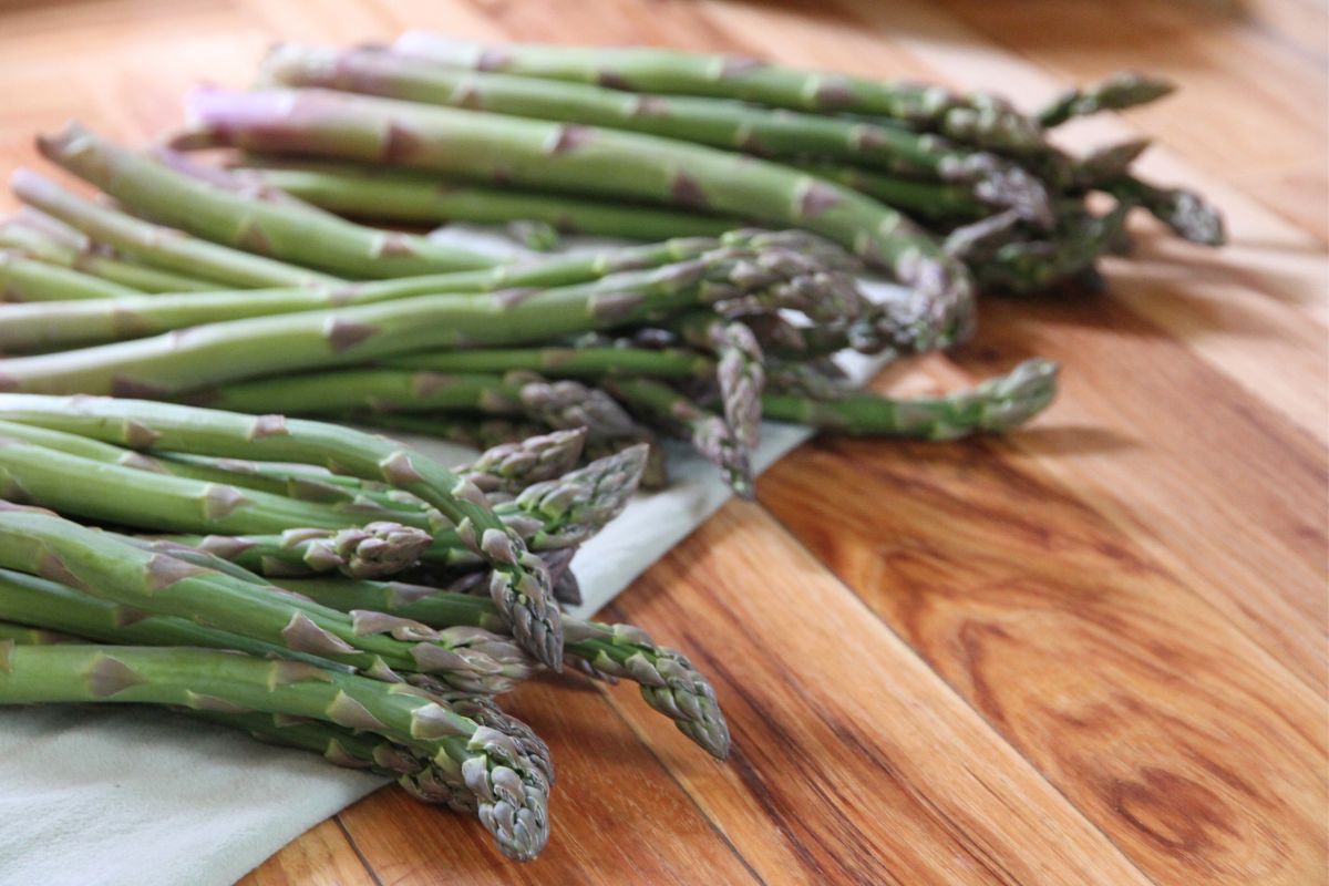 Bundles of fresh asparagus laid out on the kitchen counter