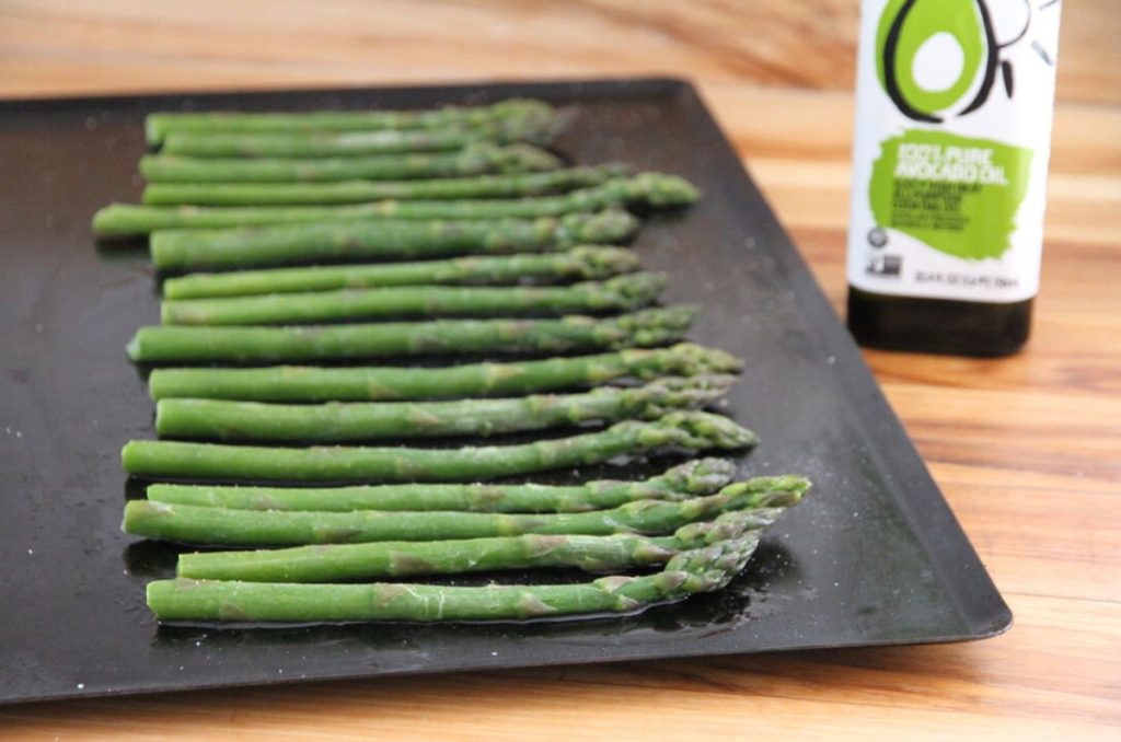 A pan of asparagus that has been drizzled in avocado oil.