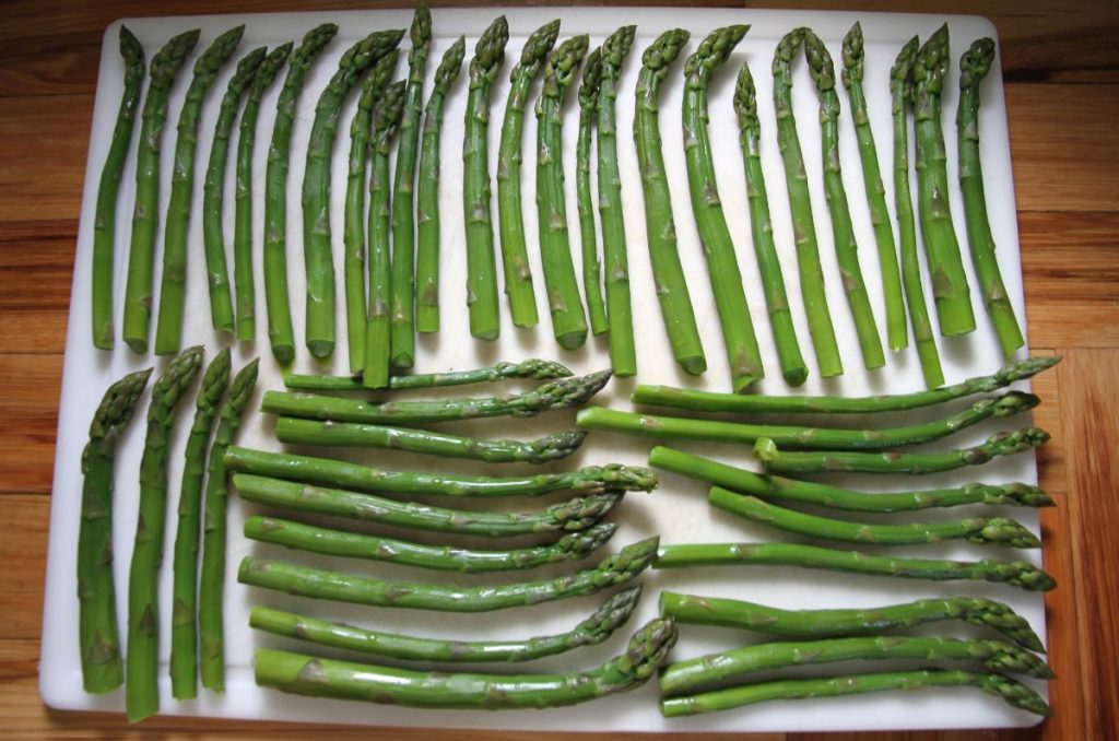 Asparagus laid out on a tray in a single layer for flash freezing.