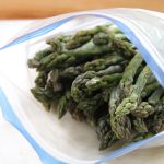 A plastic bag filled with frozen asparagus stalks.