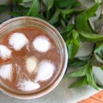A jar of refreshing chilled mint tea with ice cubes floating on top.