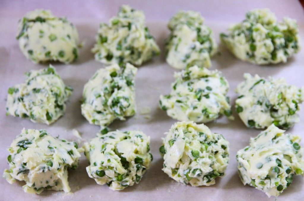 Round pats of butter that were dropped onto parchment paper like cookie dough