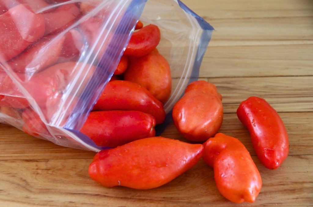 Red paste tomatoes in a zip loc freezer bag, ready to be frozen whole.