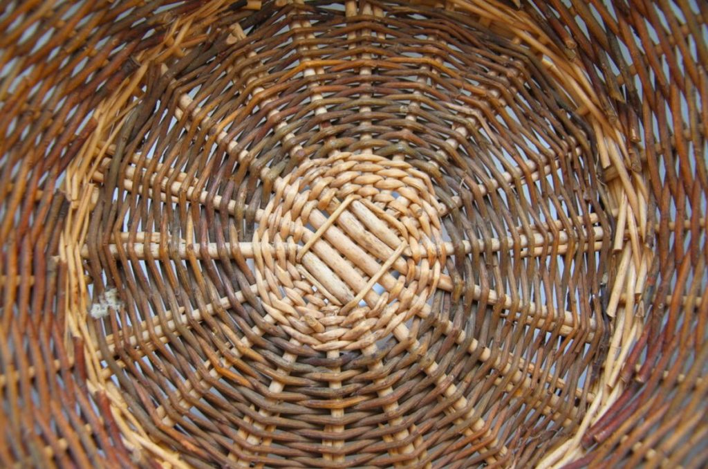 A woven wicker kitchen baskets with dirt and sticky foodstuff in the bottom.