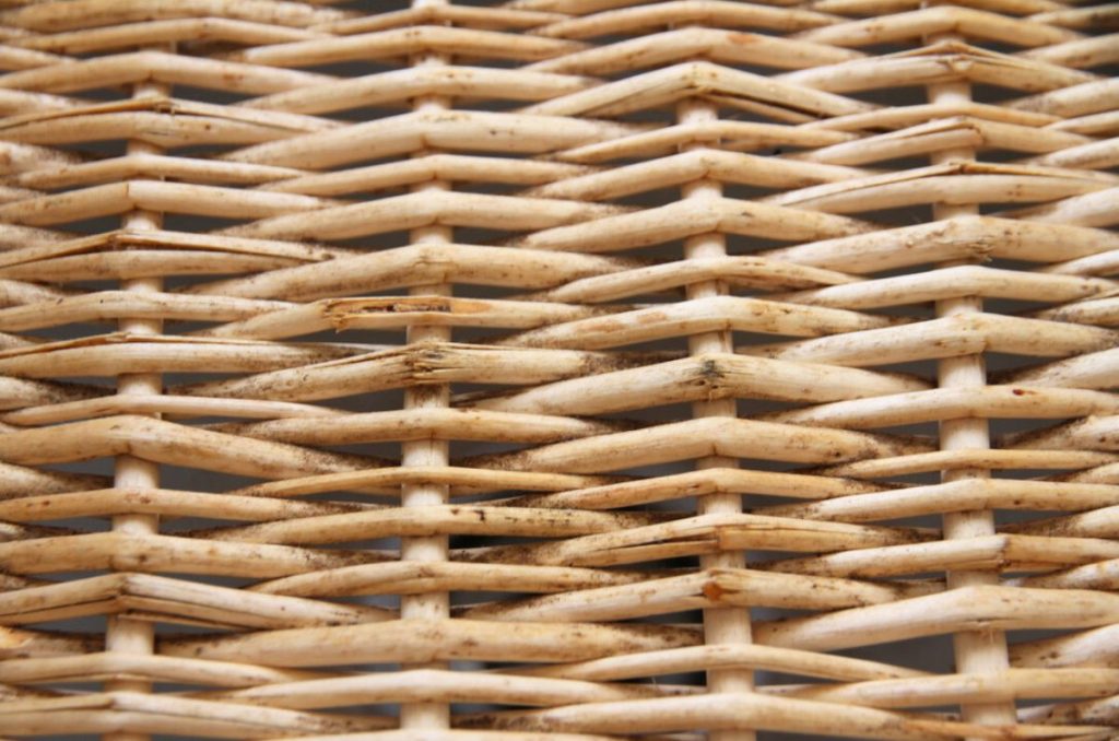 A woven wicker baskets with blue and black mold spots in the bottom.