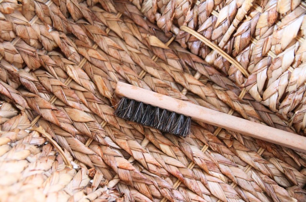 Cleaning a soft wicker baskets with a spray bottle and brush.