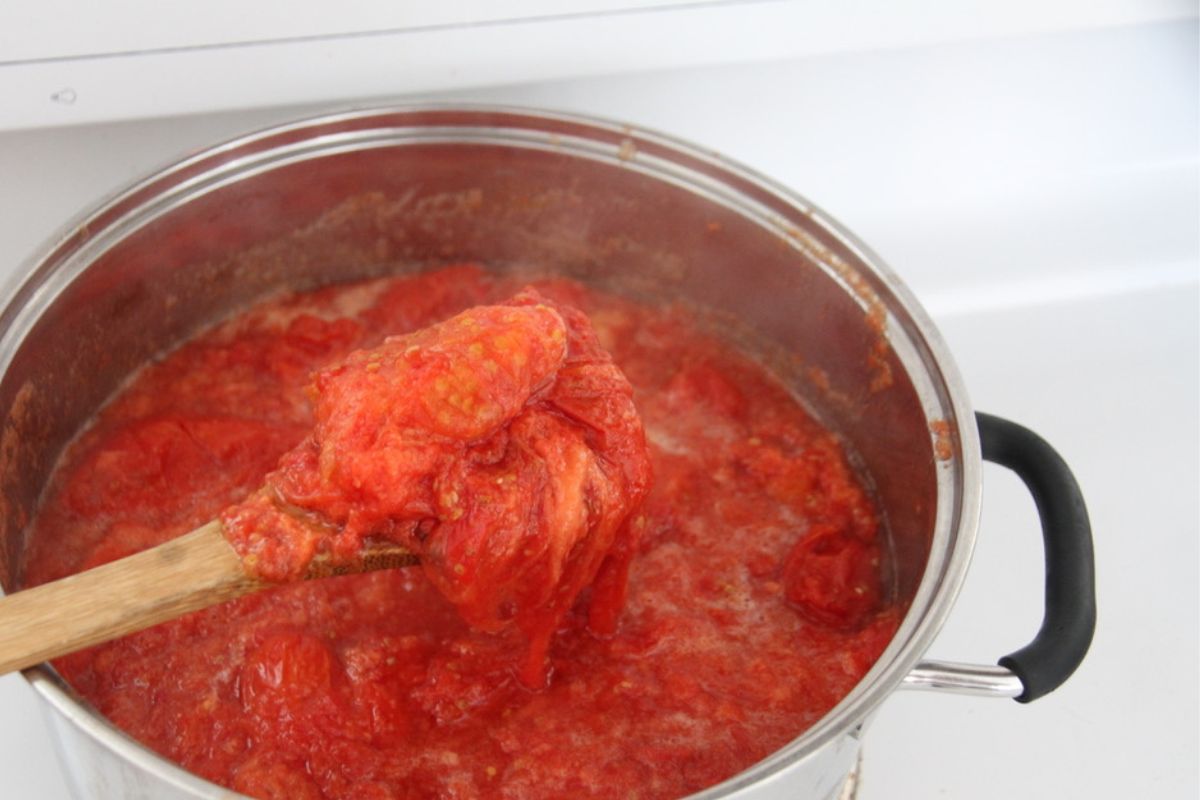 A pot filled with tomatoes that have been cooked to a mushy mess.