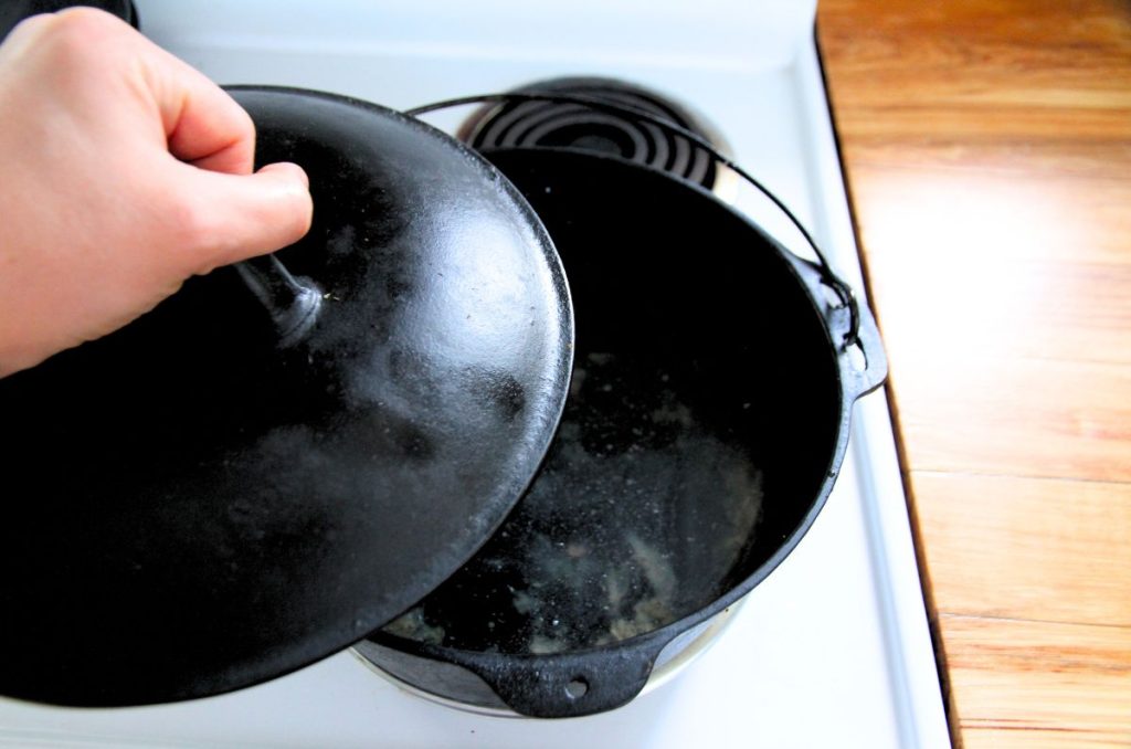 Adding a cast iron lid to a dutch-oven on the stovetop, so it can be boiled to soften burnt food and stuck-on food bits.