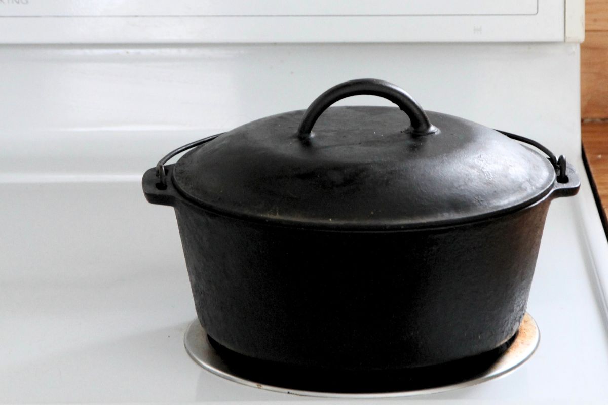 A cast iron dutch oven sitting on a white kitchen stovetop.