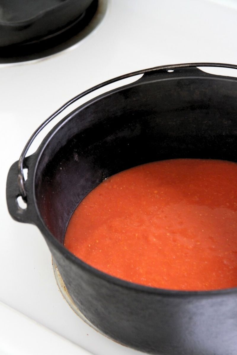 Tomato sauce simmering in a cast iron dutch oven.