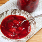 A bowl of strawberry sauce for spreading on pancakes or waffles.