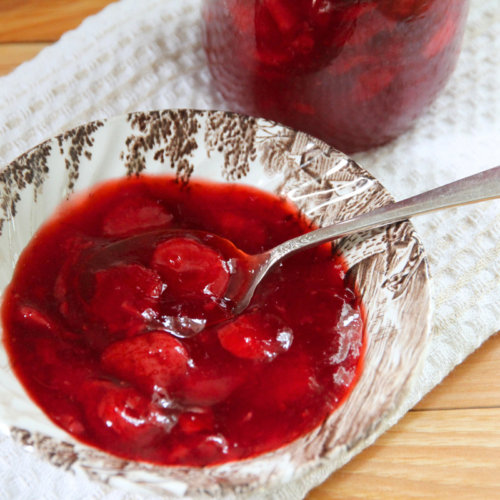 A bowl of strawberry sauce for spreading on pancakes or waffles.