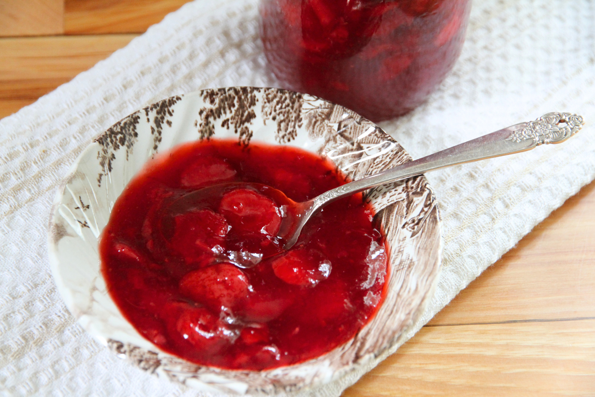 A bowl of strawberry sauce for spreading on pancakes or waffles.