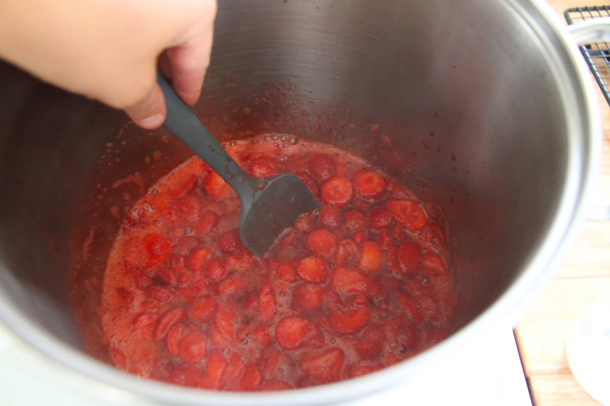 Lightly cooking strawberries on the stovetop to soften the fruit before adding pectin and honey. 