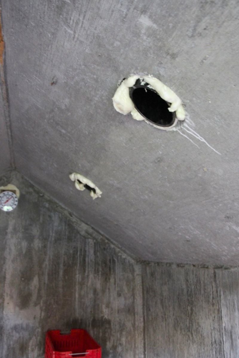 Spray foam around the ceiling vents in the concrete, root cellar roof. 