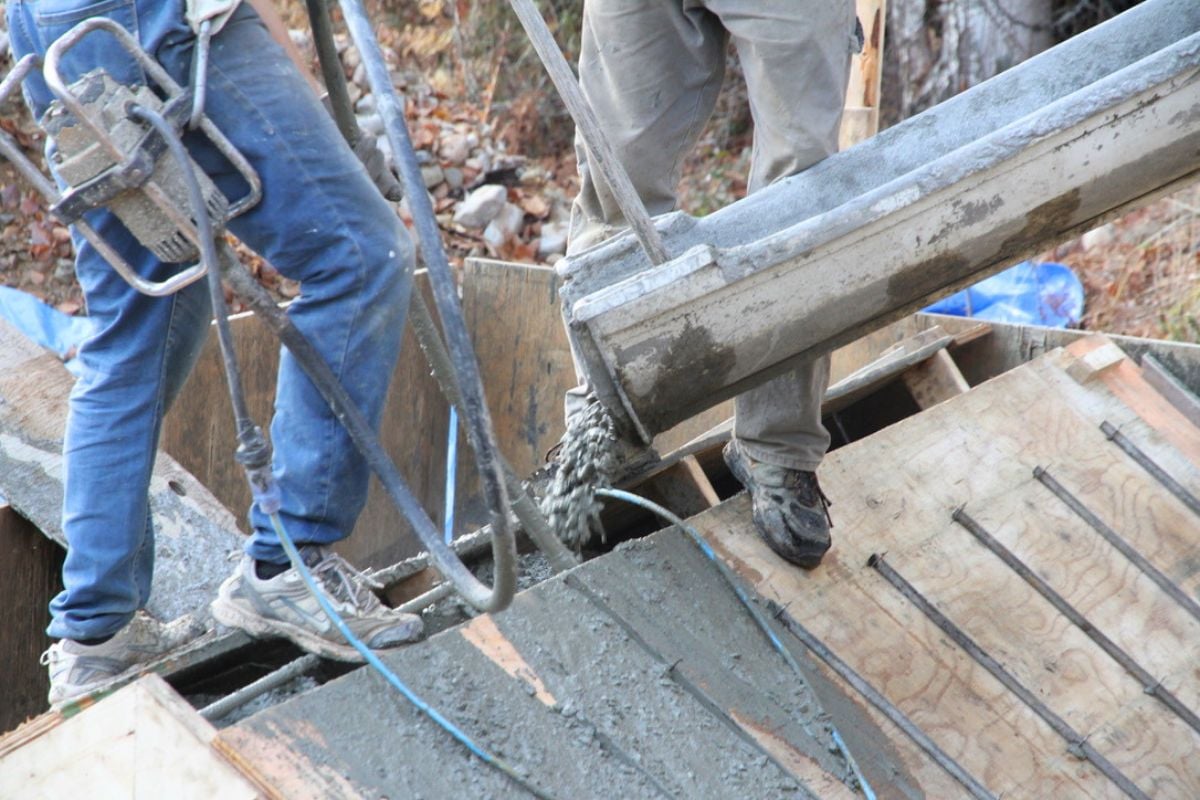 Pouring concrete into a 6 inch gap into plywood forms for the root cellar roof. 