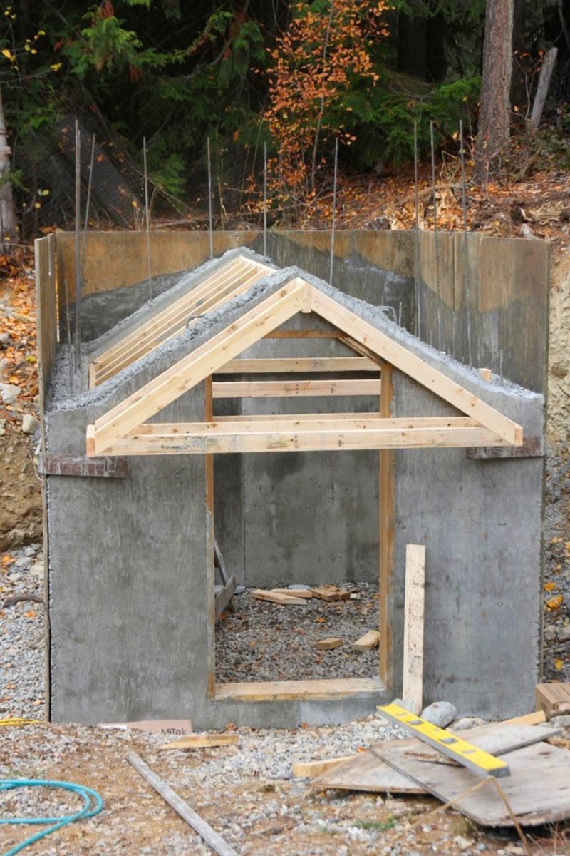 A homemade, freestanding truss system screwed to the frontside of the root cellar, to create an concrete overhang over the front door. 